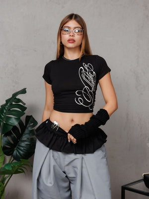 Babytee Bellakita CHILL negra cropped — algodón spandex con lettering script Bellakita en serigrafía gris claro, camiseta femenina streetwear hecha en Colombia