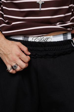 Baggy Jort CHILL negro unisex 300gr — algodón burda con estampado calligráfico en pierna y efecto tela sobrante en pretina, streetwear hecho en Colombia