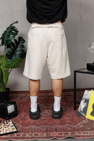 Baggy Jort CHILL BEIGE unisex 300gr — algodón burda con estampado calligráfico gótico en pierna y efecto tela sobrante en pretina, streetwear hecho en Colombia