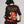 Camiseta Todo es un Parche CHILL oversize negra — algodón peruano 250gr con diablillo cartoon y lettering script en serigrafía naranja, streetwear hecho en Colombia