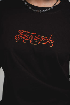 Camiseta Todo es un Parche CHILL oversize negra — algodón peruano 250gr con diablillo cartoon y lettering script en serigrafía naranja, streetwear hecho en Colombia