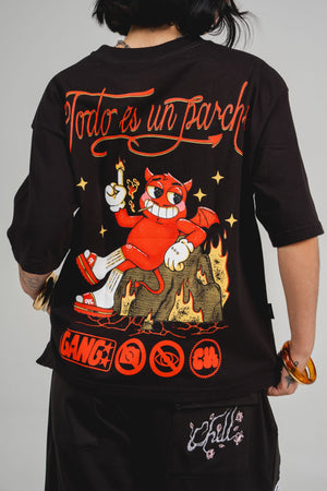 Camiseta Todo es un Parche CHILL oversize negra — algodón peruano 250gr con diablillo cartoon y lettering script en serigrafía naranja, streetwear hecho en Colombia
