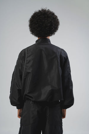 Chaqueta Reborn CHILL negra boxy fit — antifluido con detalles reflectivos y estampado tribal serigrafía, streetwear hecho en Colombia