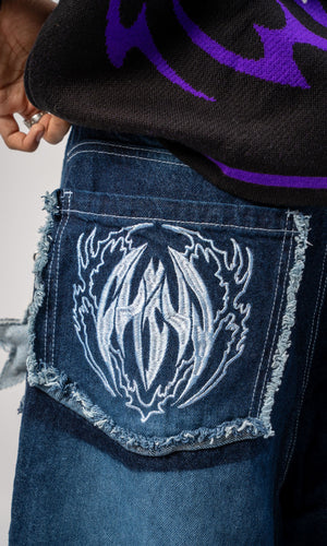 Jeans baggy CHILL azul washed — denim con bordes deshilachados curvos y bordado tribal, streetwear hecho en Colombia