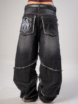 Jeans baggy CHILL negro washed — denim con bordes deshilachados curvos y bordado tribal, streetwear hecho en Colombia