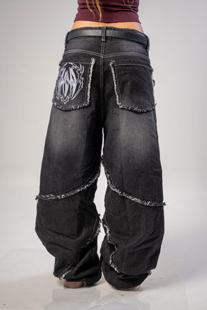 Jeans baggy CHILL negro washed — denim con bordes deshilachados curvos y bordado tribal, streetwear hecho en Colombia