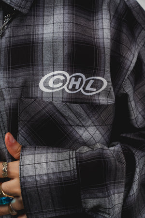 Leñadora Chill world wide negra boxy fit manga larga unisex — camisa a cuadros con lettering script en espalda y CHL en pecho en serigrafía, streetwear hecho en Colombia