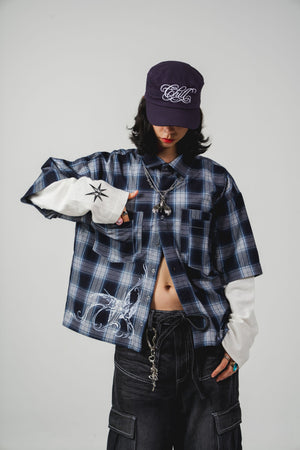 Leñadora Under The Sky CHILL azul boxy fit unisex — camisa a cuadros con doble manga blanca, golondrinas y lettering script en serigrafía, streetwear hecho en Colombia