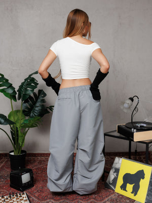 Top off shoulder Bellakita CHILL blanco cropped — algodón spandex con manga asimétrica y lettering script en serigrafía roja, top femenino streetwear hecho en Colombia