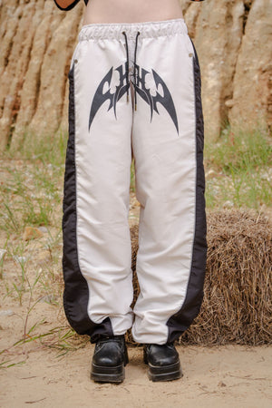 Parachute Track CHILL Crudo — pantalón baggy antifluido con estampado tribal, streetwear hecho en Colombia