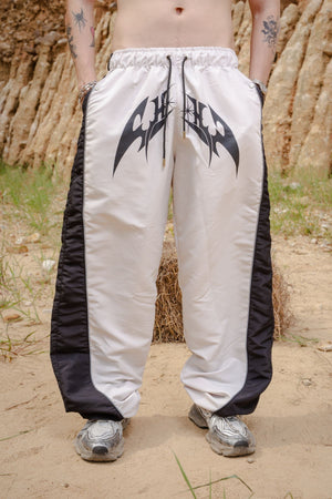 Parachute Track CHILL Crudo — pantalón baggy antifluido con estampado tribal, streetwear hecho en Colombia
