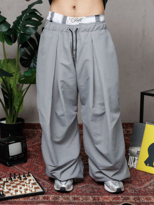 Parachute Balloon CHILL gris unisex — poliéster balloon fit con pliegues frontales estilo moda asiática, pretina cuadriculada y ajustables en botas, streetwear hecho en Colombia