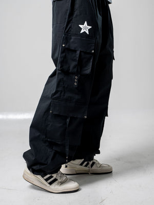 Parachute Hollow CHILL negro — pantalón baggy antifluido con bolsillos cargo y broches metálicos, streetwear hecho en Colombia