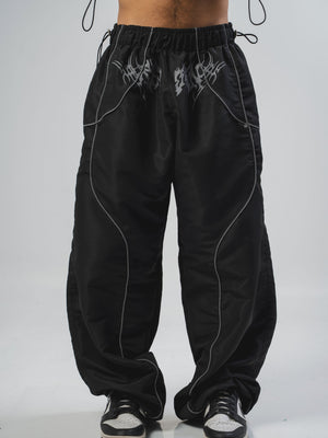 Parachute Reborn CHILL negro — pantalón baggy antifluido con detalles reflectivos y estampado tribal serigrafía, streetwear hecho en Colombia