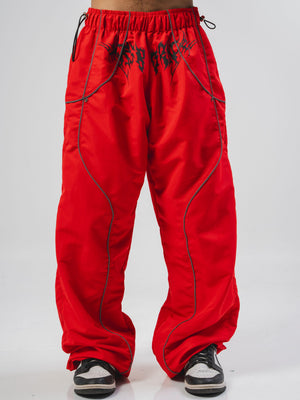 Parachute Reborn CHILL rojo — pantalón baggy antifluido con detalles reflectivos y estampado tribal serigrafía, streetwear hecho en Colombia