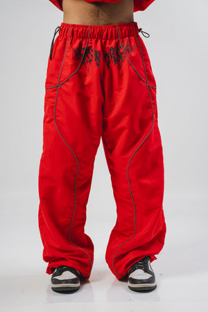 Parachute Reborn CHILL rojo — pantalón baggy antifluido con detalles reflectivos y estampado tribal serigrafía, streetwear hecho en Colombia