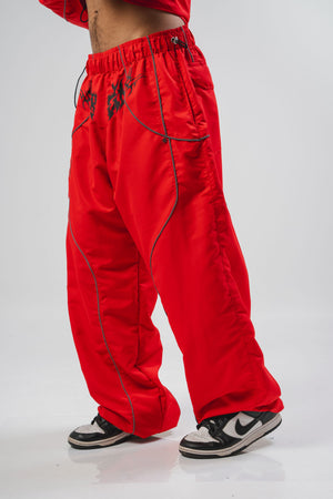 Parachute Reborn CHILL rojo — pantalón baggy antifluido con detalles reflectivos y estampado tribal serigrafía, streetwear hecho en Colombia