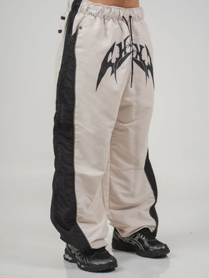 Parachute Track CHILL Crudo — pantalón baggy antifluido con estampado tribal, streetwear hecho en Colombia
