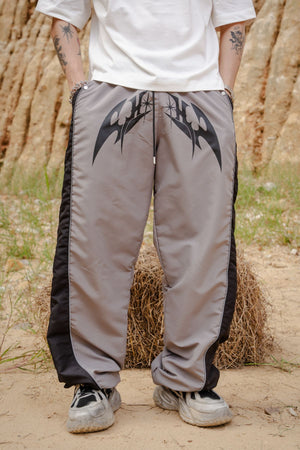 Parachute Track CHILL gris — pantalón baggy antifluido con estampado tribal, streetwear hecho en Colombia