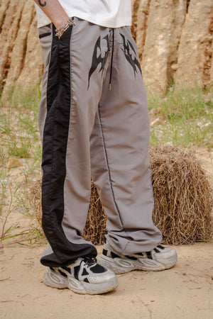 Parachute Track CHILL gris — pantalón baggy antifluido con estampado tribal, streetwear hecho en Colombia