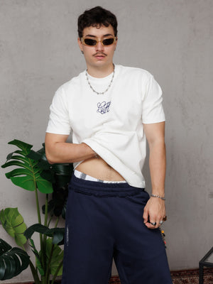 Camiseta regular fit CH Goth CHILL crudo unisex — 100% algodón peruano 250gr con monograma gótico CH en serigrafía azul marino, básico premium streetwear hecho en Colombia