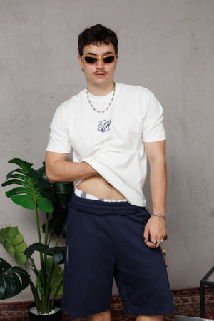 Camiseta regular fit CH Goth CHILL crudo unisex — 100% algodón peruano 250gr con monograma gótico CH en serigrafía azul marino, básico premium streetwear hecho en Colombia