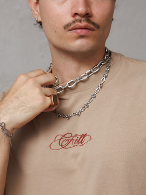 Camiseta regular fit Chill Classy CHILL beige unisex — 100% algodón peruano 250gr con lettering Chill script en serigrafía vinotinto, básico premium streetwear hecho en Colombia